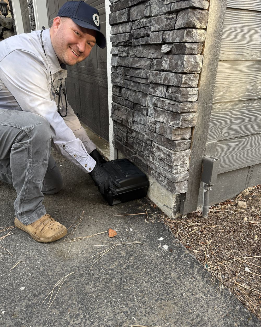 Lion Gate technician placing a rodent bait station